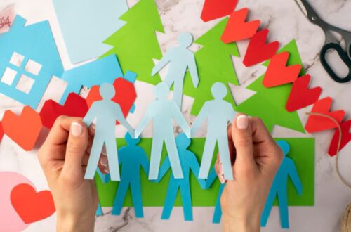 Mãos de um adulto e uma criança se tocando sobre documentos, simbolizando o processo legal e afetivo da adoção.