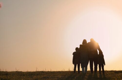 Uma imagem suave de um adolescente e uma criança de mãos dadas, olhando para um horizonte claro, simbolizando esperança e apoio na saúde mental da criança e adolescente adotados.