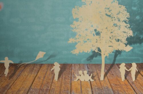 Uma criança desenhando uma árvore genealógica estilizada com corações, simbolizando a origem da criança adotada e a construção de sua identidade.