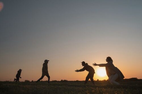 Um adulto e uma criança mais velha (talvez um adolescente) sorrindo e conversando em um ambiente acolhedor,